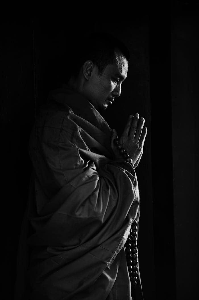 Offerings Grayscale image depicting a monk in deep meditation, highlighting spiritual serenity.